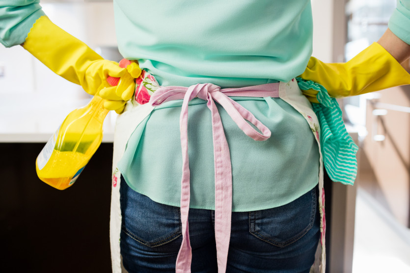 1679564162.0897woman-standing-with-spray-bottle-and-napkin-in-kitchen.jpg